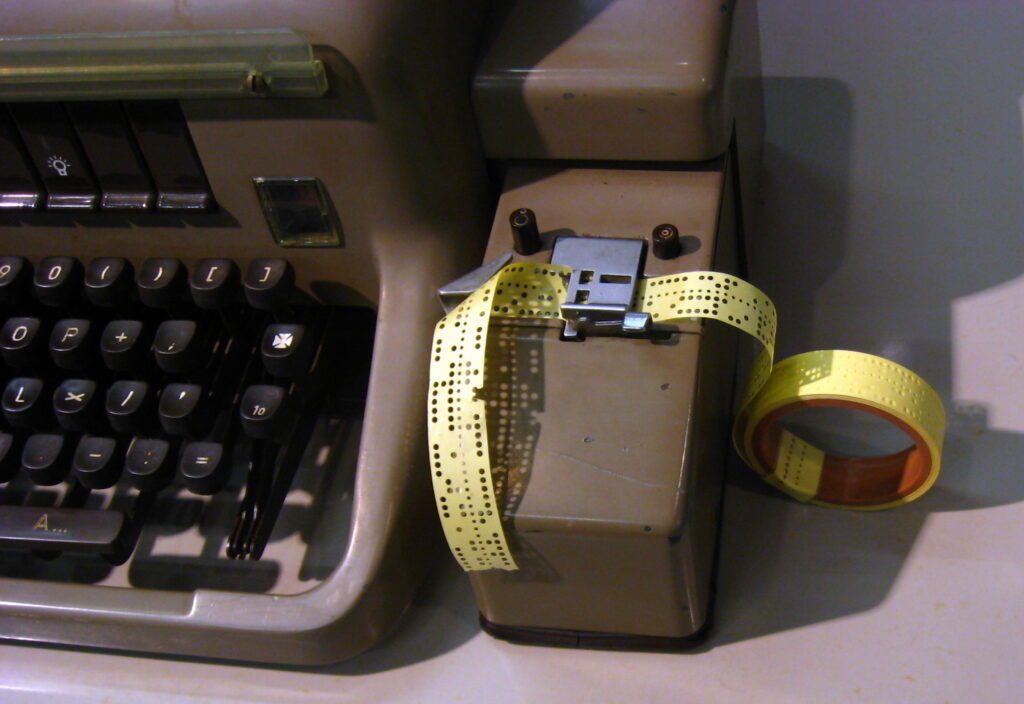 Gammel hulstrimmel i en maskine, som bruges som visuel analogi for DNA’s lange informationsstrenge.