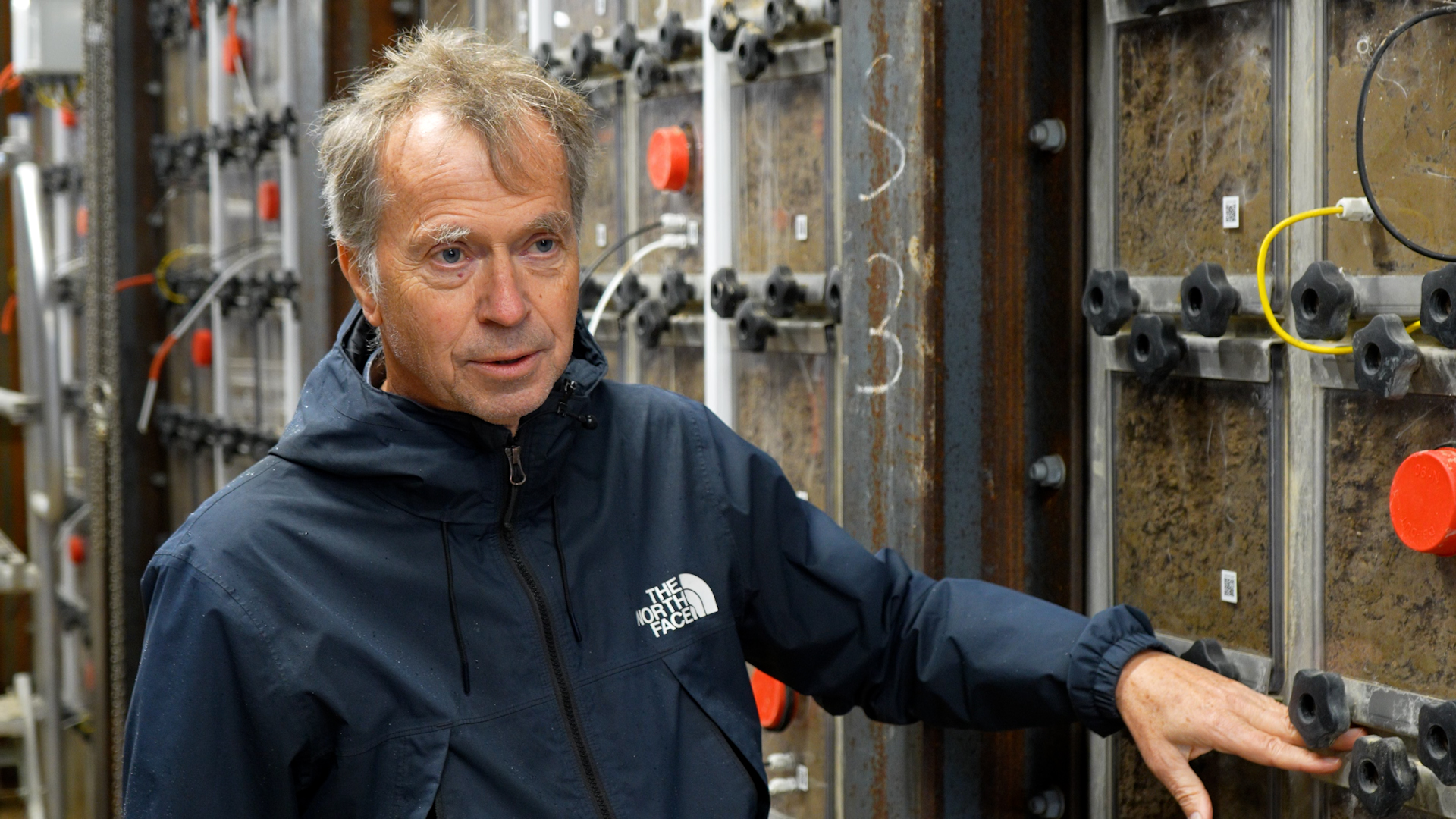 Professor Kristian Thorup-Kristensen demonstrerer rodvækst og jordprofiler i et forskningsanlæg med gennemsigtige jordkasser på Københavns Universitet